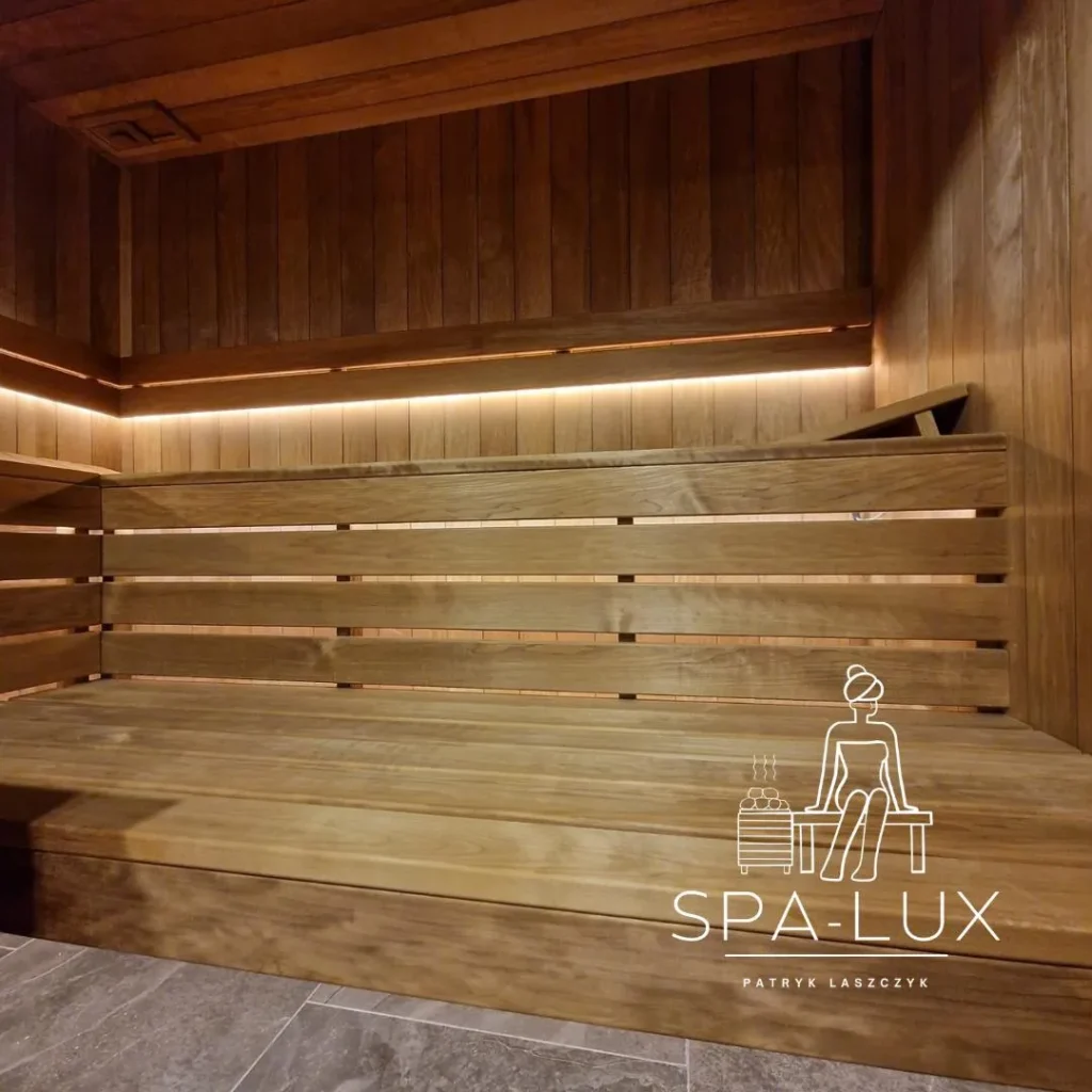 drewniana sauna fińska z szeroką ławką, oparciem i ciepłym oświetleniem LED
