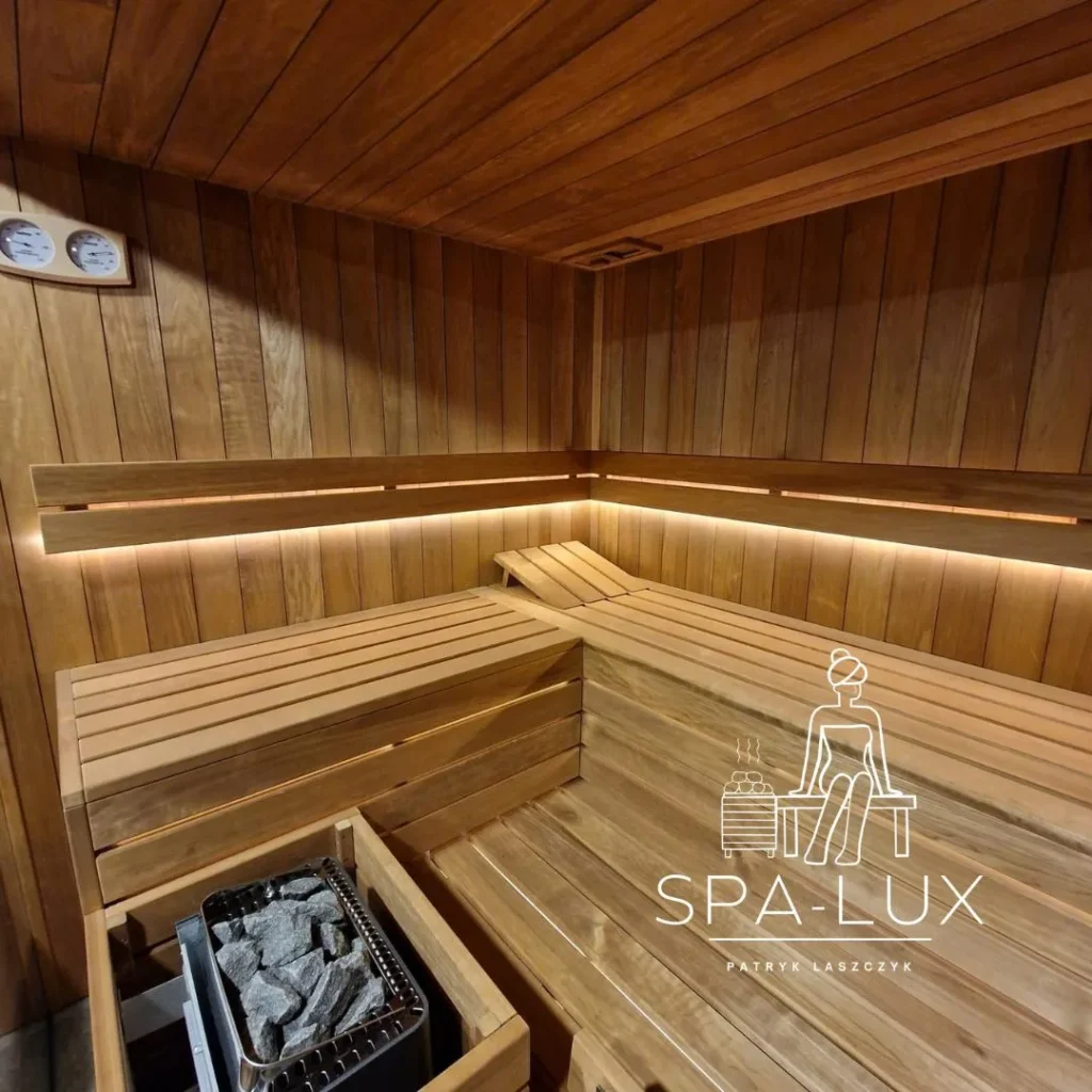 narożna sauna fińska z drewnianymi ławkami, piecem i ciepłym podświetleniem LED