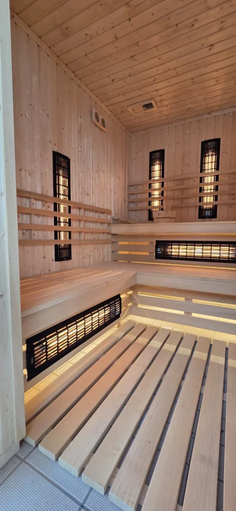 sauna infrared z jasnego drewna z promiennikami przy ławkach i podświetlaną podłogą